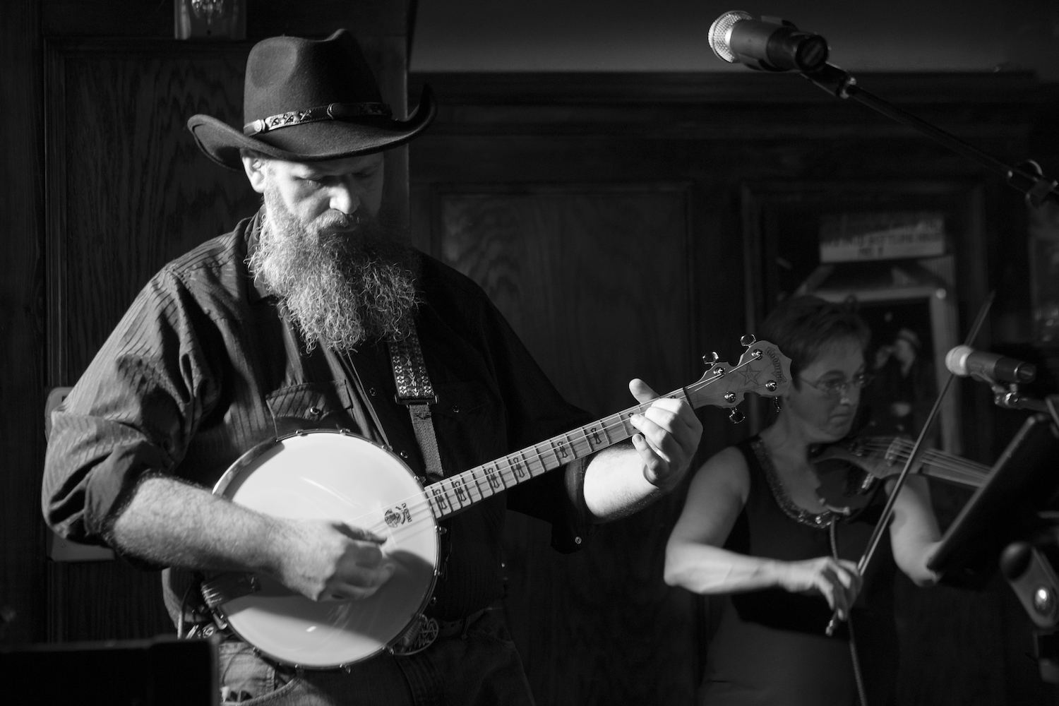 Man on stage with cowboy hat, large beard, and a tenor banjo